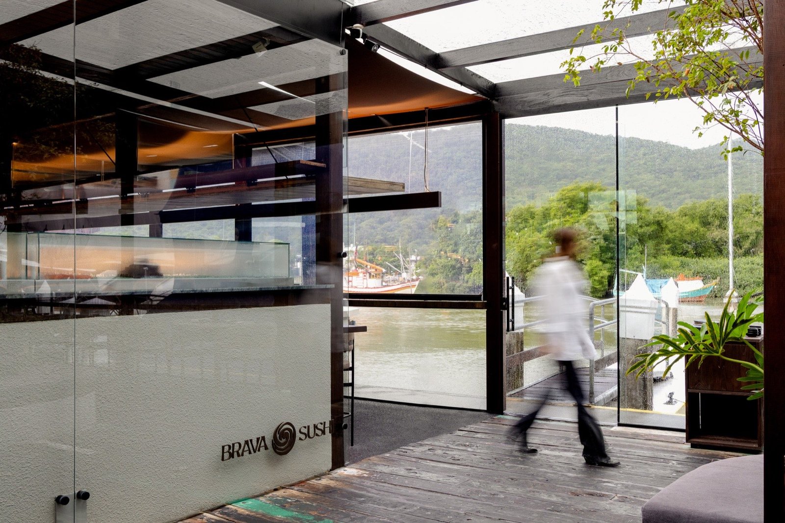 Entrada do restaurante Brava Sushi com deck e pergolado de madeira