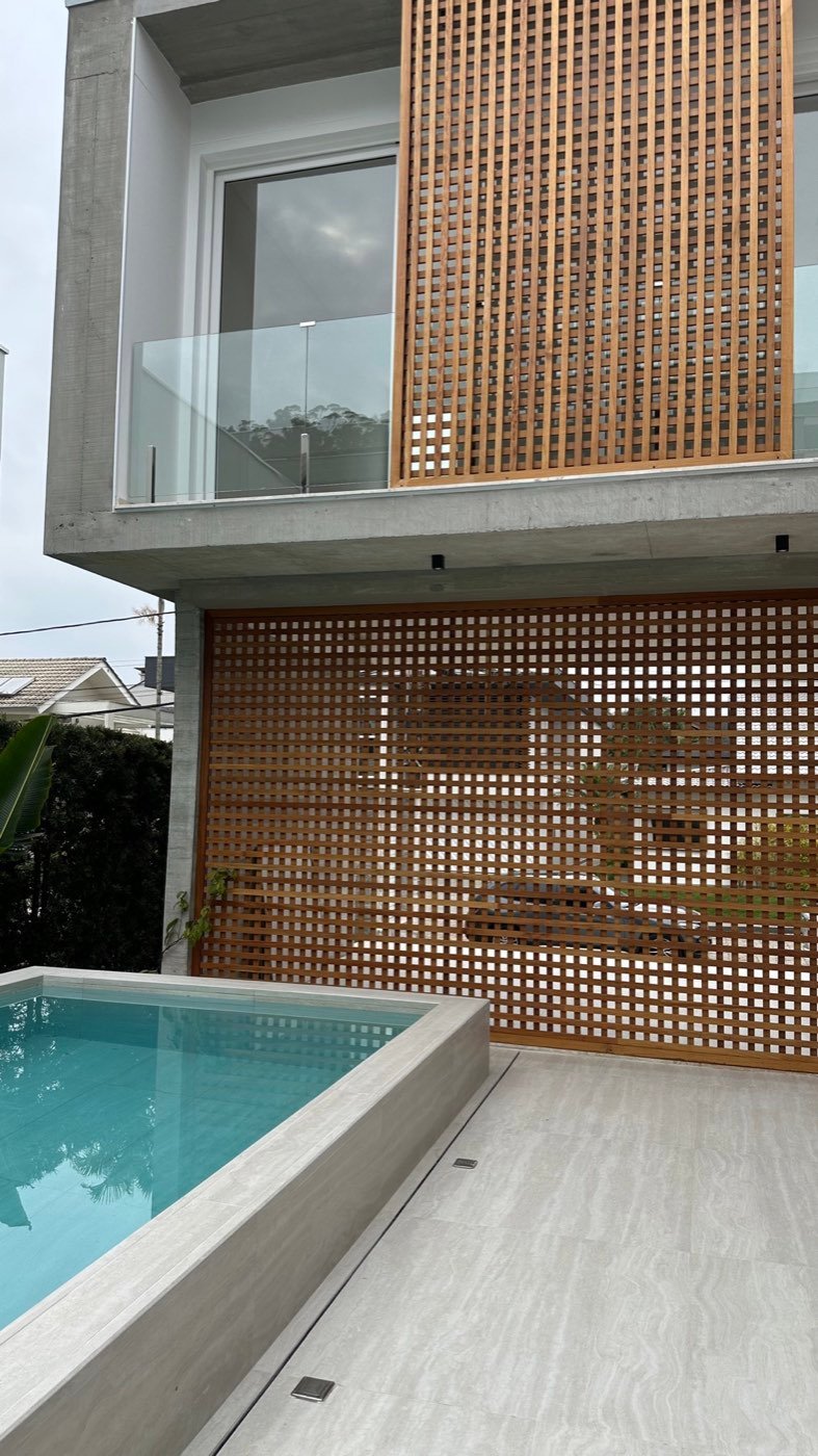 Parede de muxarabi em madeira ao lado da piscina