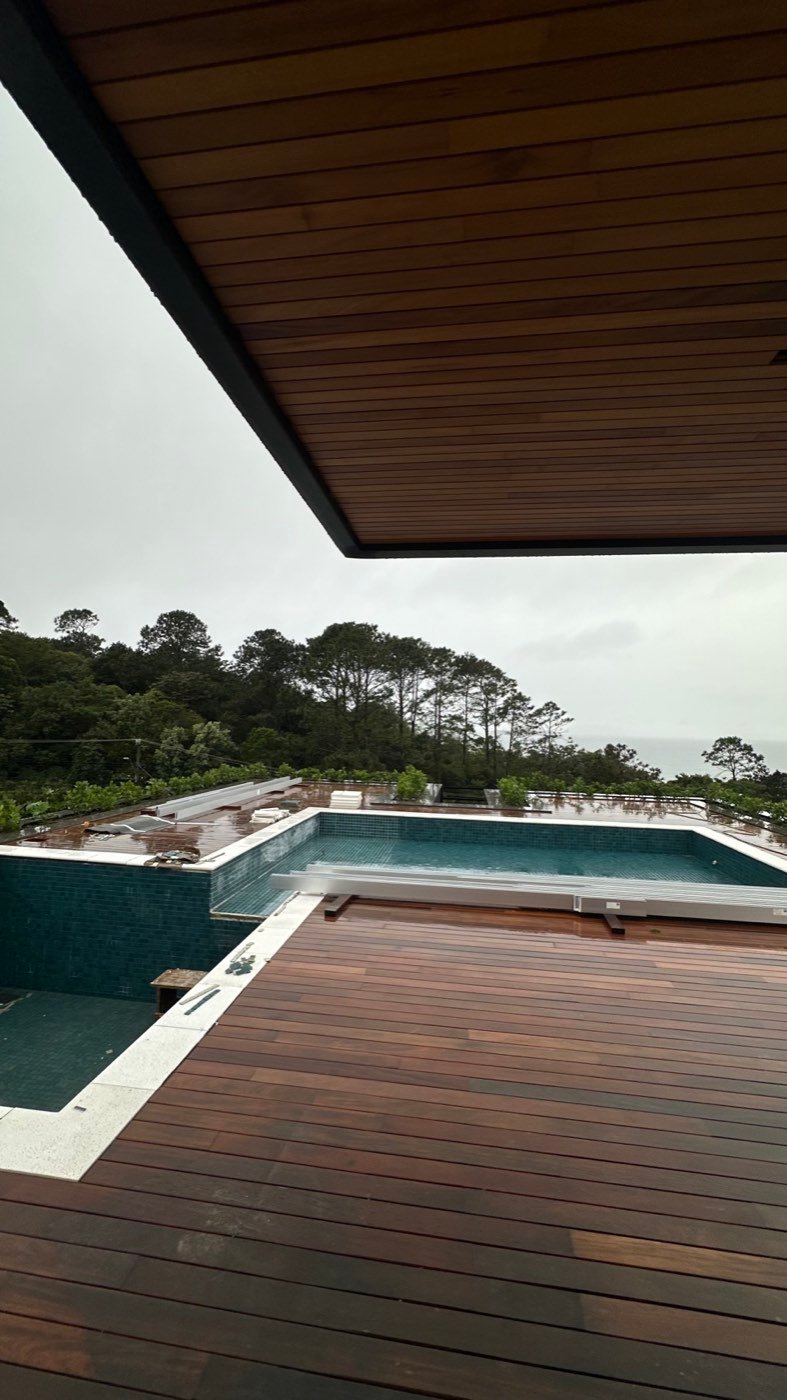 Deck e ofuro do Residencial Maui com o forro de madeira avançando sobre a varanda e o mar ao fundo